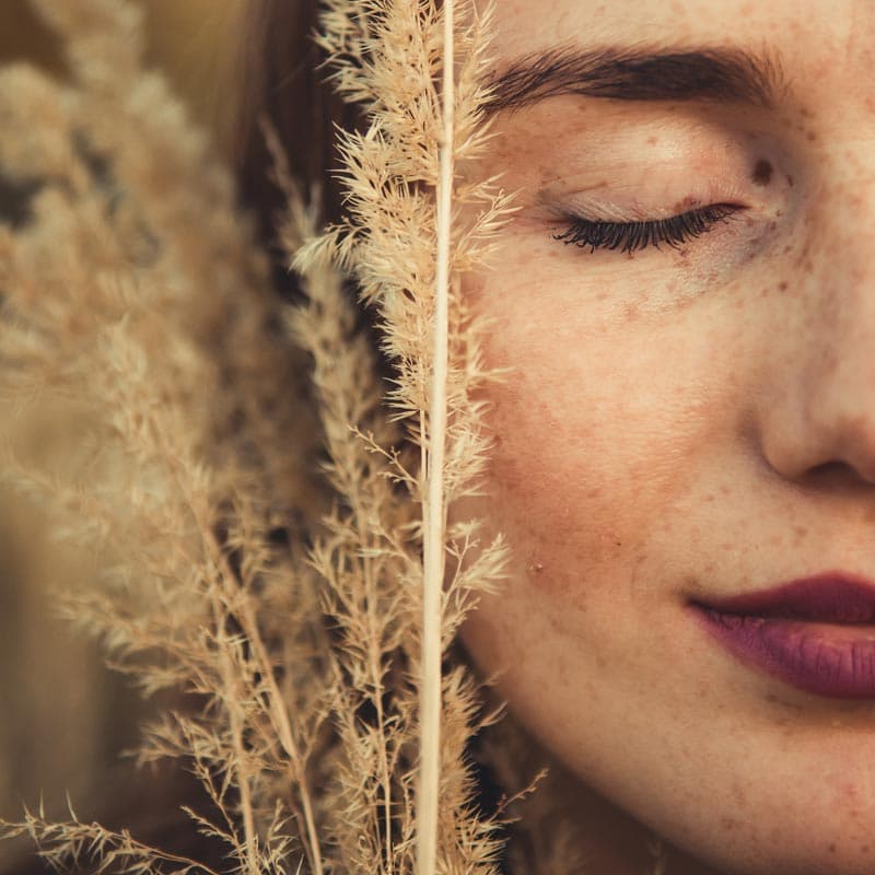 Visage en gros plan montrant une peau bien hydratée et lumineuse, grâce aux soins d'automne